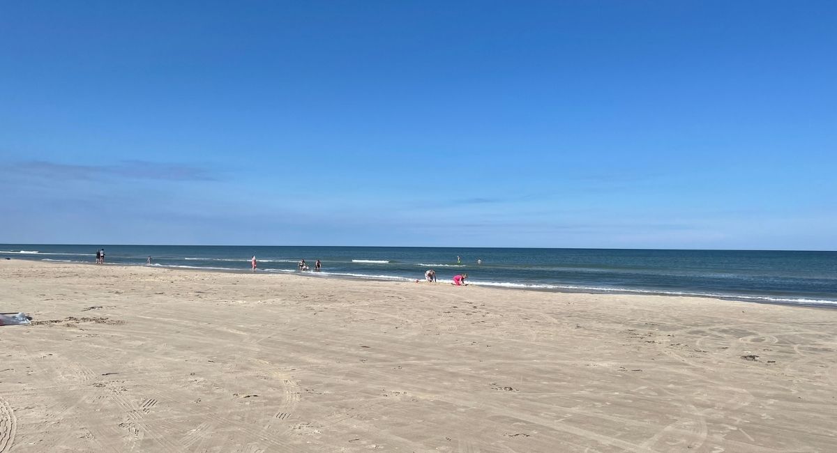 Den populära och breda stranden i Blokhus med vita badhytter.