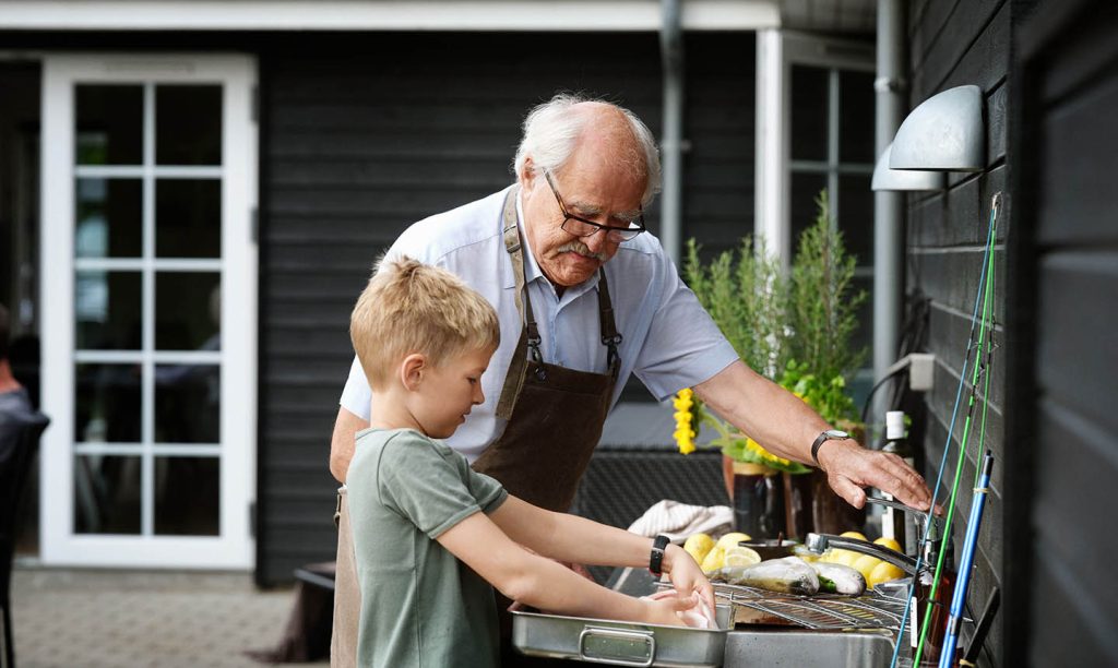 Farfar lagar fisk med barnbarnet
